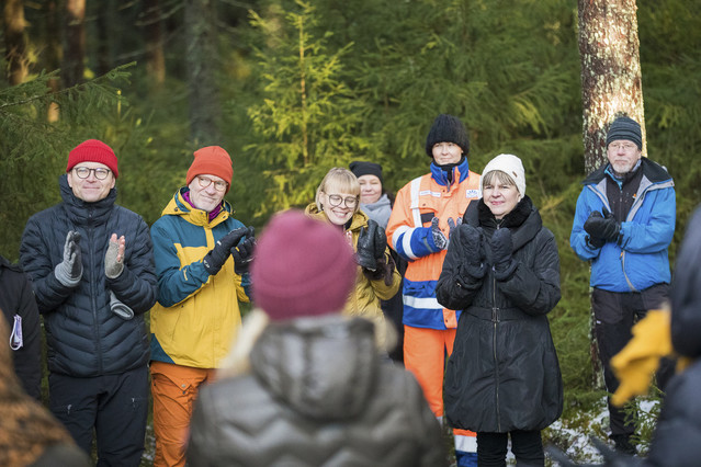 Vaikuttajat taputtavat puhujalle metsässä.